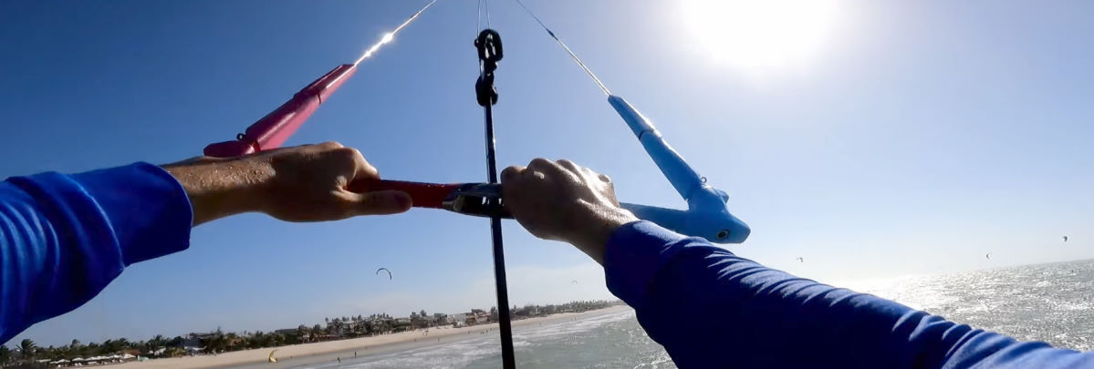 How hard do you have to pull to sheet in? A kiteboarder grips the bar with both hands during a jump. a