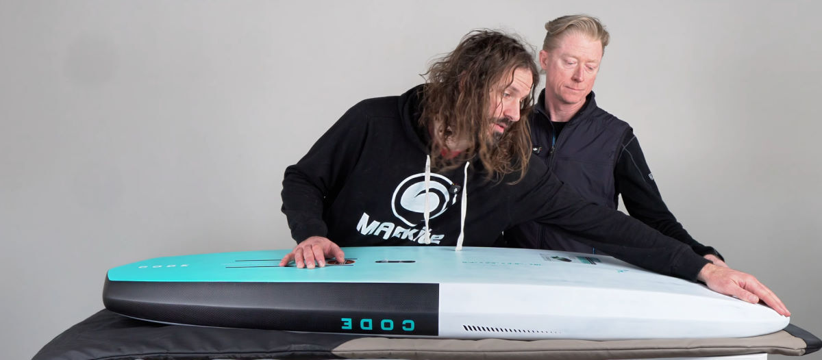 Tucker looks at the rails on the Code foilboard.