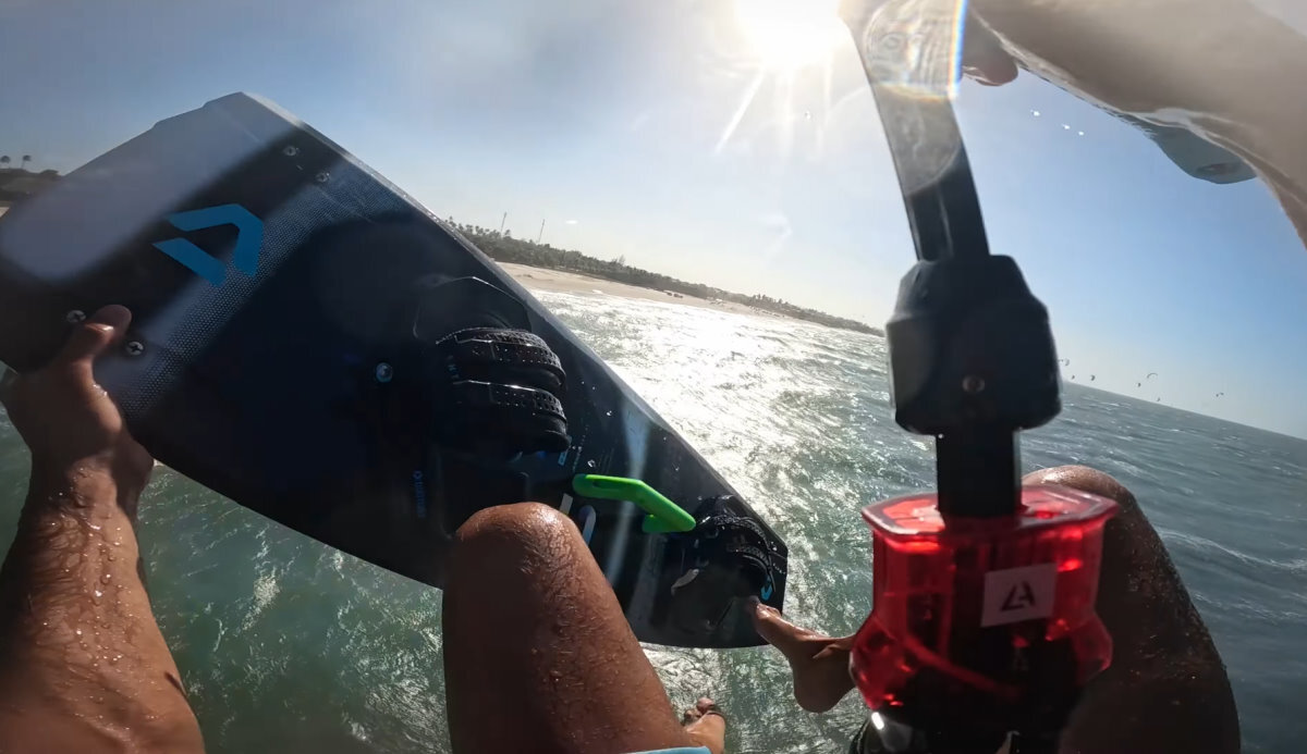 First-person view of a kiteboarder taking his board off his feet during a jump.