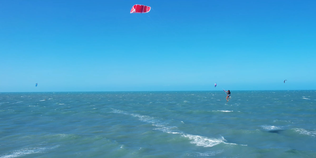 A kiteboarder performs a kiteloop during a jump.