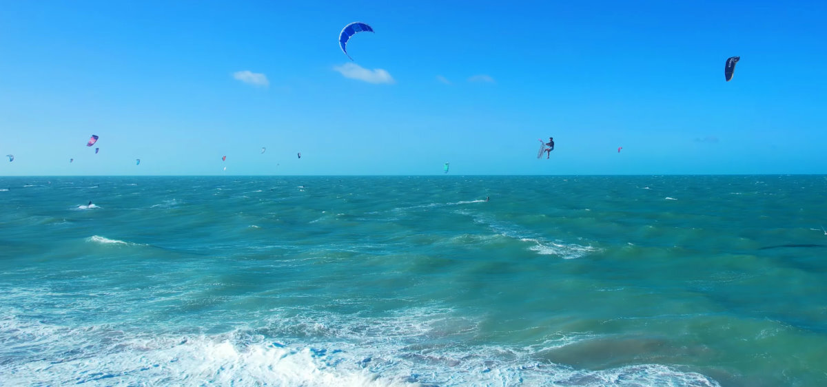 A kiteboarder jumps high to do a trick.
