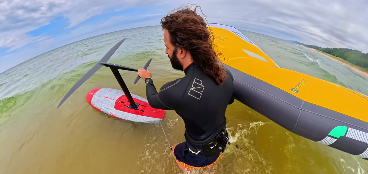 Tucker walks out with a wing, board and foil for a test session.