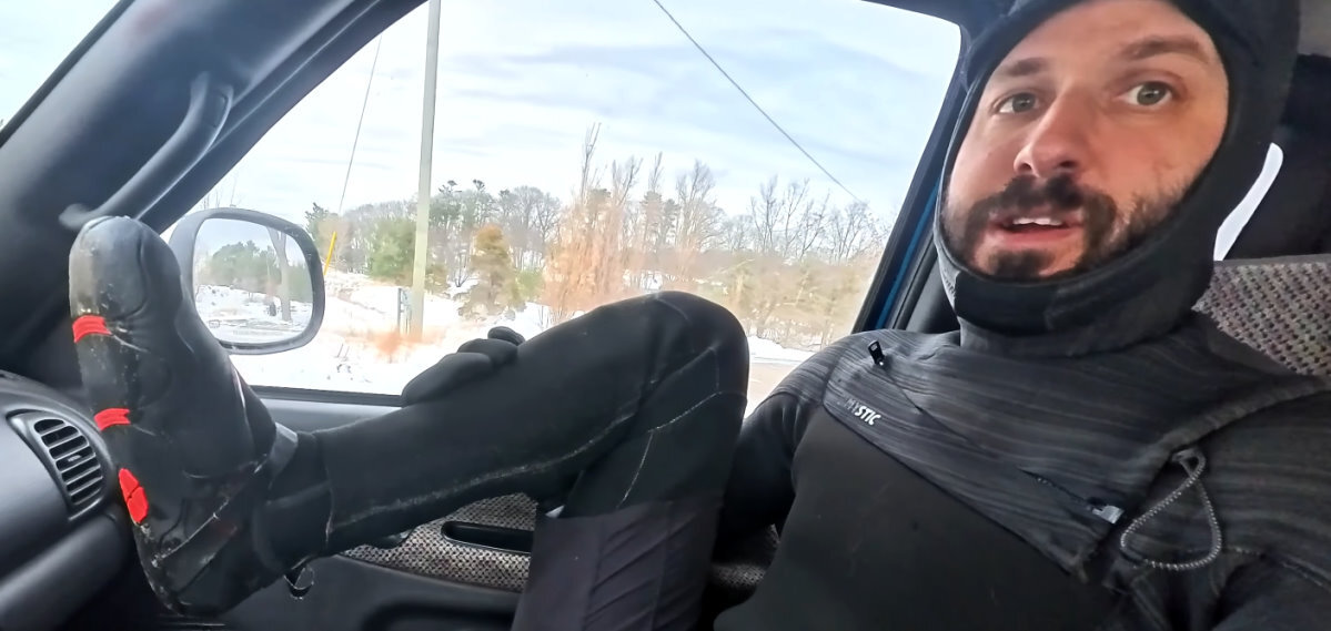 Tucker holds up his foot to show off his water boots.