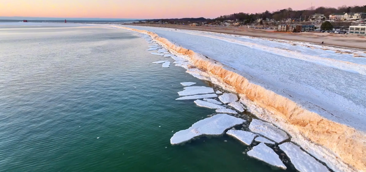 An ice shelf forms along the coast of Lake Michigan in the winter.