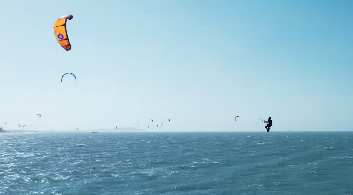 A kiteboarder performs a kiteloop while jumping.