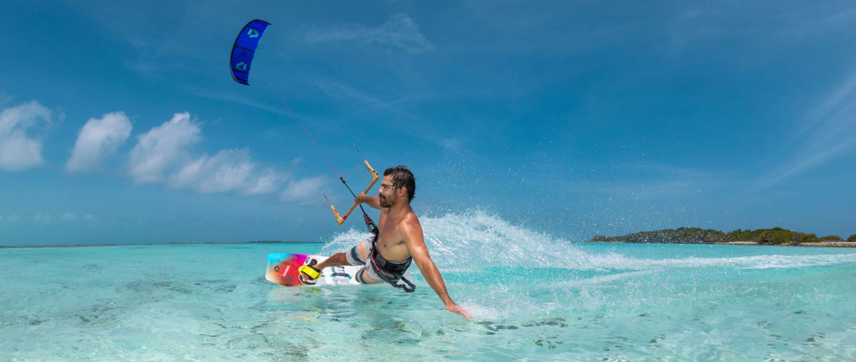 A kiteboarder rides fast across the tropical waters.