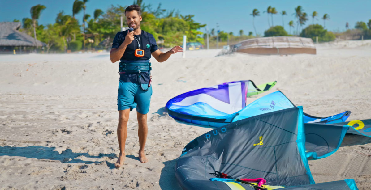 The Evo D/LAB or Thrive? The choice is yours! A kiteboarder stands on the beach next to two kites.