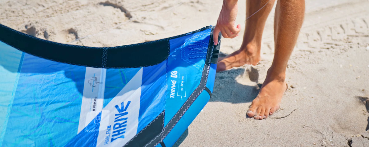 Light bar pressure makes the kite feel less intimidating. A kiteboarder points to the setting for light bar pressure on the wingtip of the kite.