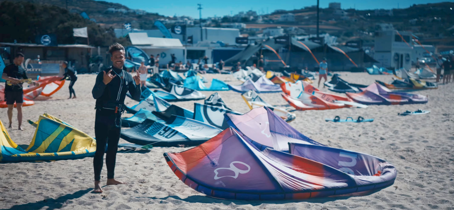 The Brazilian Brothers are stoked to get more time kiteboarding on the F-One Trigger kite. Rubens stands on the beach next to the Trigger, stoked to get more time on it.