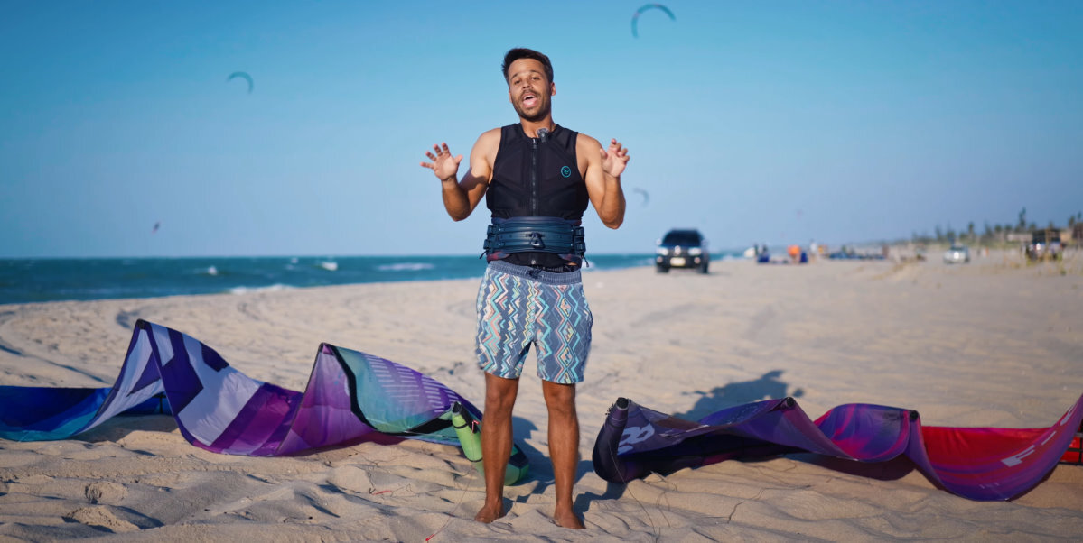Rubens stands on the beach in front of the Thrive and Trigger kites.