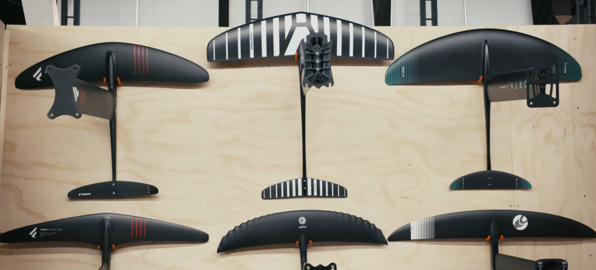 A variety of foils hang on a wall.