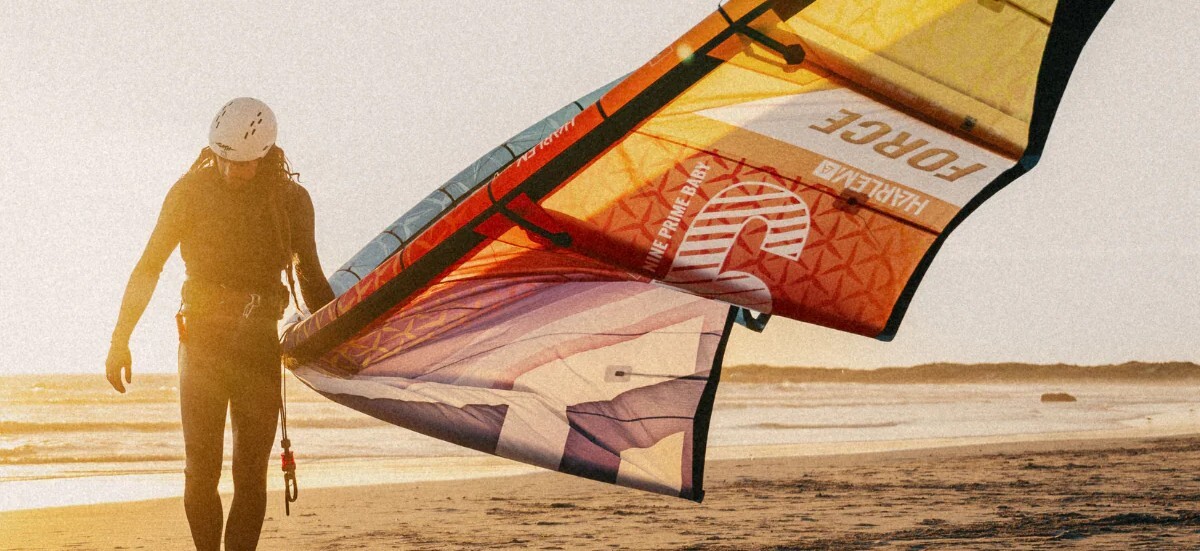 Holding a Harlem Kite while walking on the beach