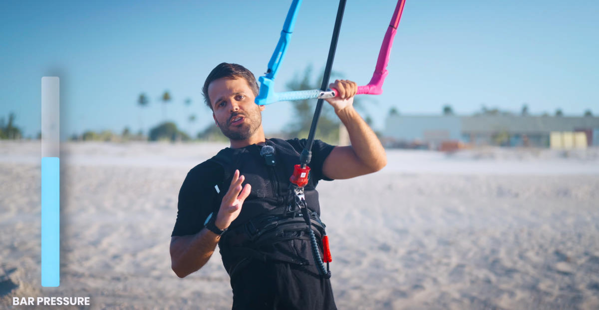 Rubens stands on the beach holding onto the kite bar.