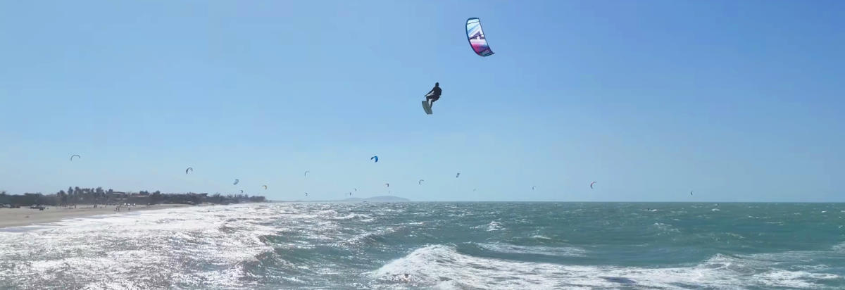 A kiteboarder performs a kiteloop while jumping.