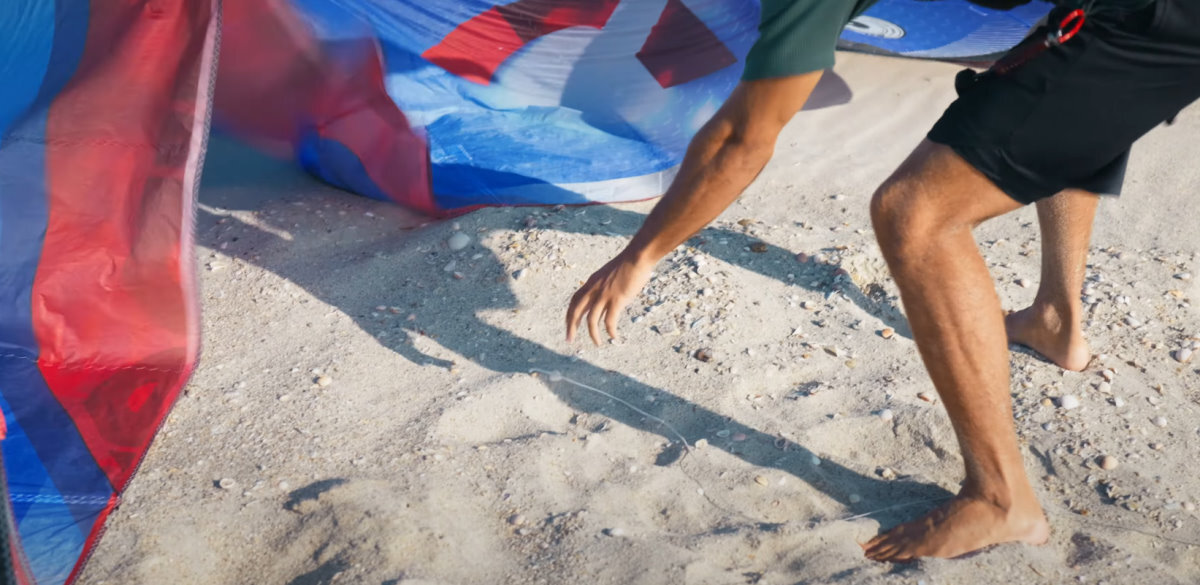 Set each line near its place on the kite. A kiteboarder separates the ends of his lines at the kite.