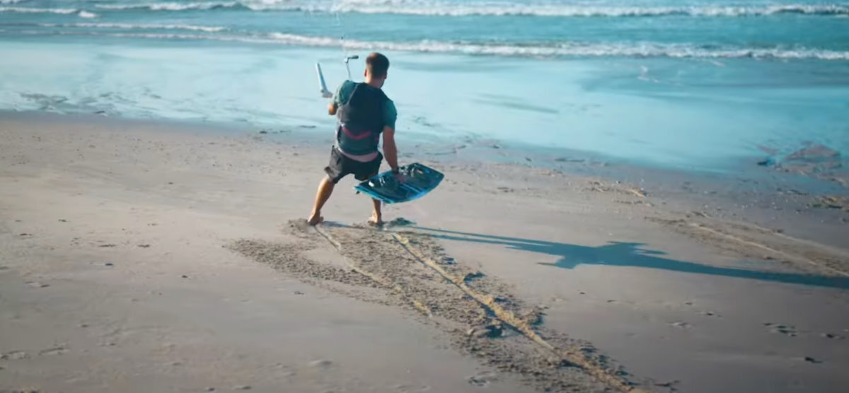 A safe launch is the first step to a great session! A kiteboarder lets his kite pull his across the beach and down to the water.