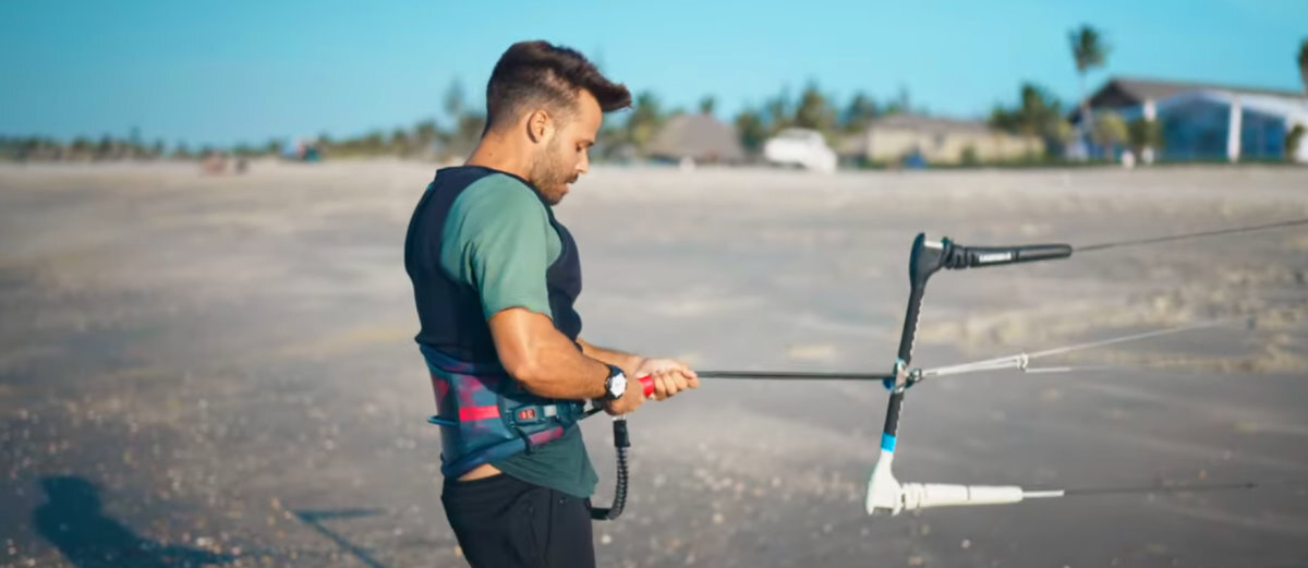 Now you can finally hook in! A kiteboarder connects his loop to his harness.
