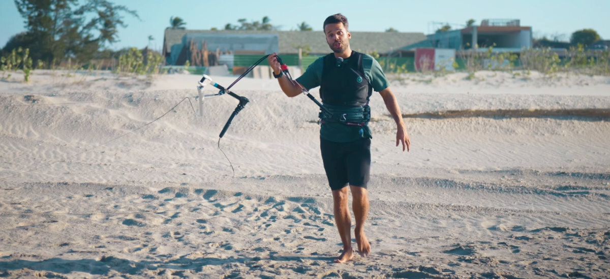 Start with the safety leash. You can hook in later. A kiteboarder walks with his safety line in his hand.