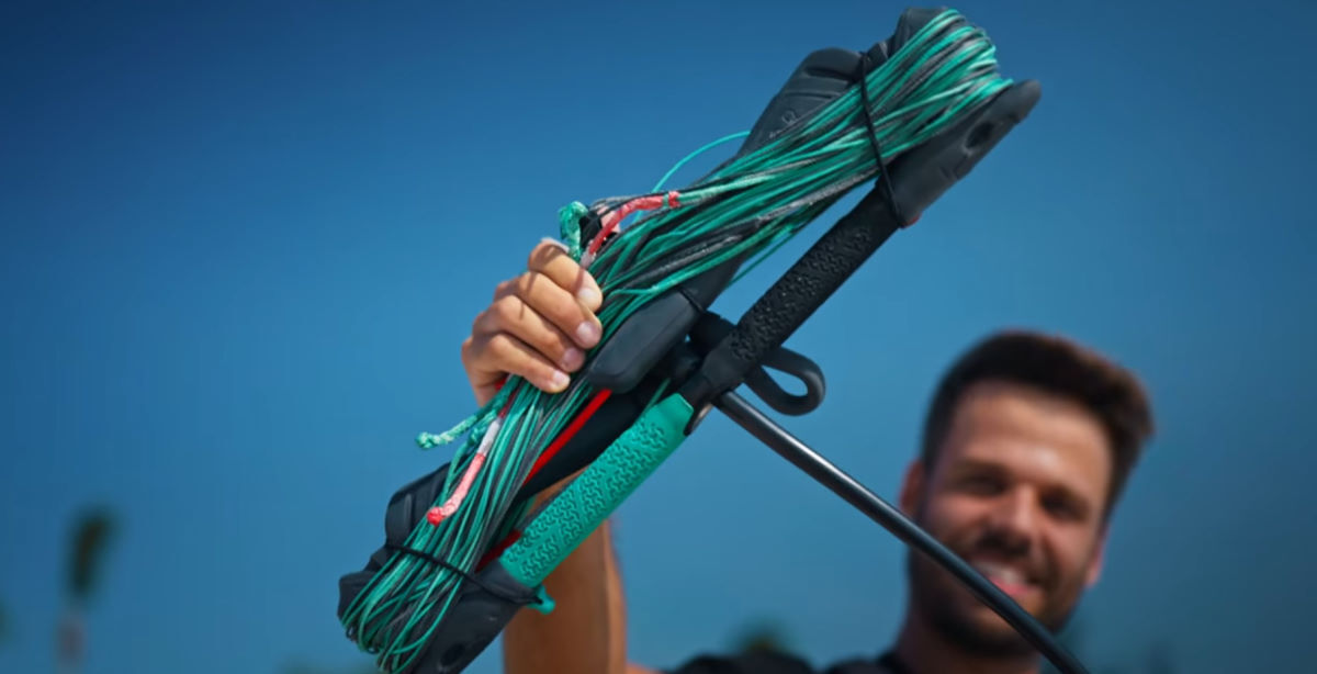 It's time for a control bar tune-up! Rubens holds up a kite bar with the lines wound up on it