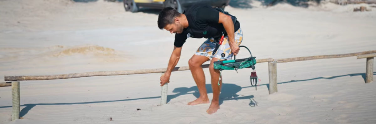 Yep- it'll hold! Rubens checks the strength of a post in the sand.