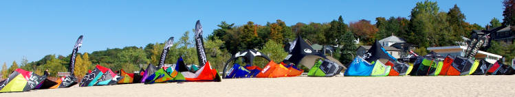 New kiteboarding gear lined up on the beach