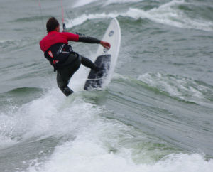 Cresting a wave with the kiteboard's nose up