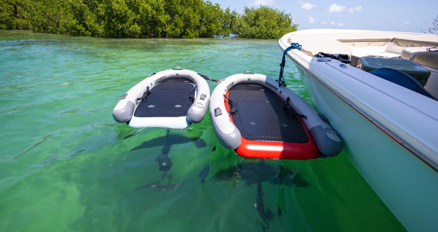 The Blowfish pod almost guarantees success. Two Lift eFoils outfitted with the Blowfish inflatable pod float next to a boat.