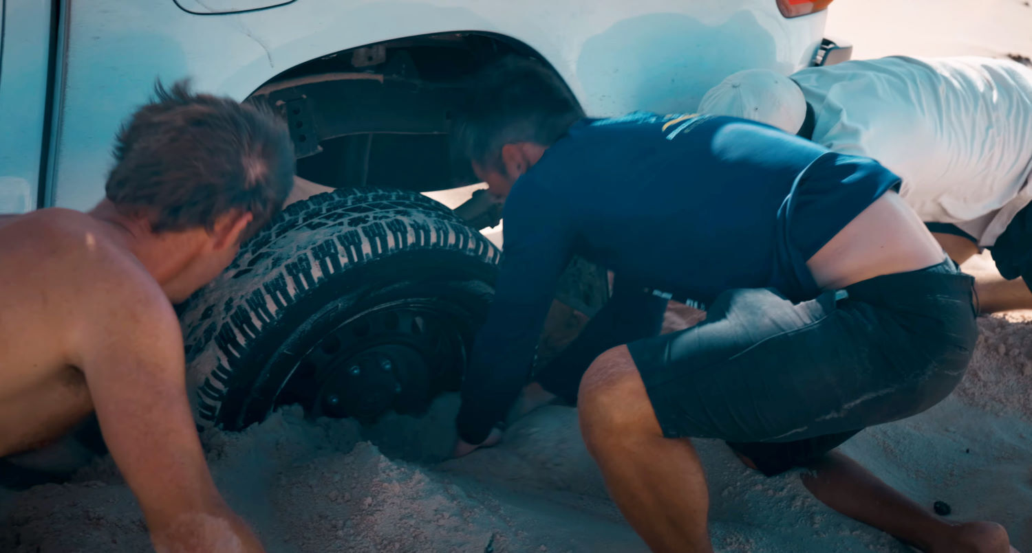 Even a stuck truck won't stop Nick. The guys dig out a tire sunk deep into the sand.