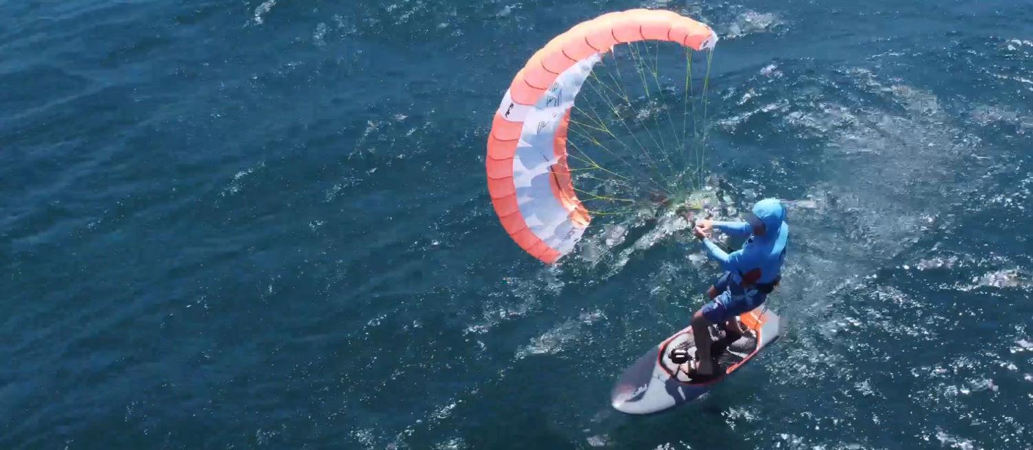 Cruising is surprisingly satisfying with a parawing. A parawinger cruises across the water.