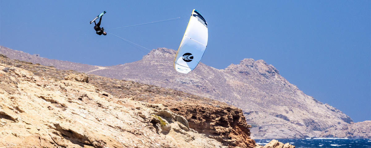 A kiteboarder flies high on a kite with an Aluula frame.