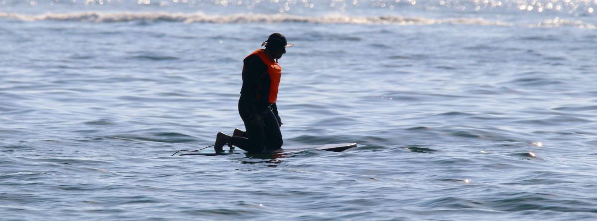 A foiler kneels on a new board to get a feel for it.