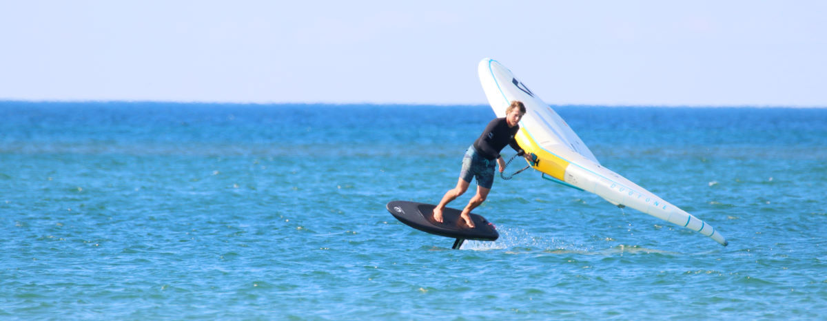 A wing foiler turns while riding.