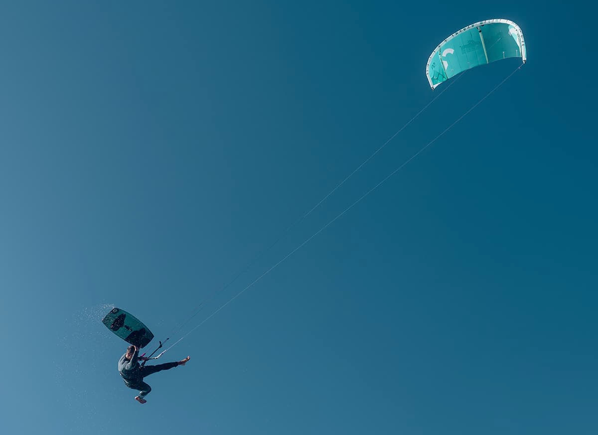 A kiteboarder jumps high into the air with the Supermodel kite.