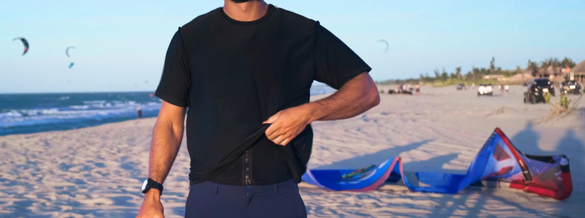 A kiteboarder wears a shirt over his impact vest.