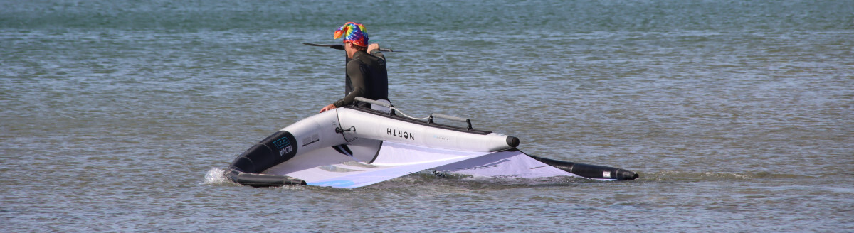 If at first you don't succeed, fly, fly again. A winger walking his gear out into the lake.