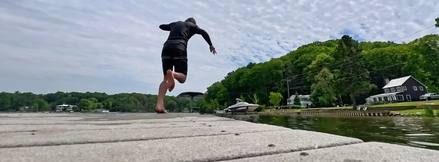 Be sure to jump like you mean it! Tucker jumps off the end of the dock and onto his foilboard.