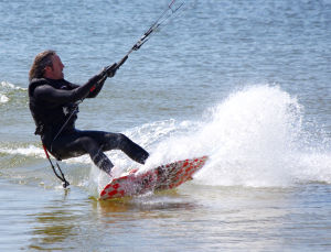 Aaron kiteboarding in a wetsuit